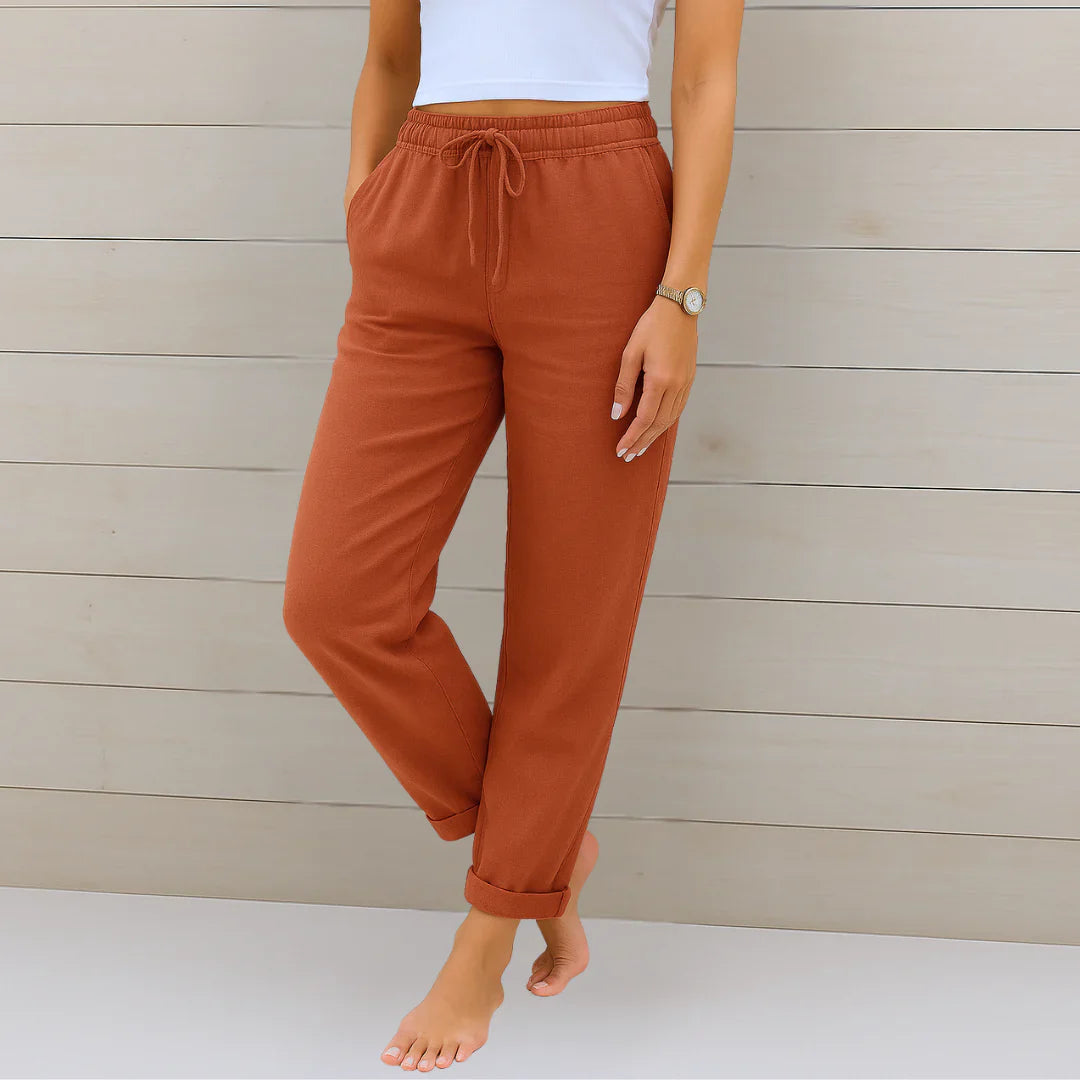 Rust orange linen stretch trousers with elastic drawstring waist and cuffed ankle hems