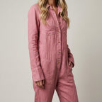 Pink linen jumpsuit with button front, V-neck collar, long sleeves, and roomy jumpsuit legs