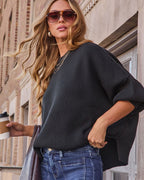 Black oversized knit pullover sweater with wide batwing sleeves and crew neck