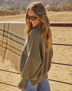 Olive green knit pullover sweater with ribbed cuffs and relaxed shoulder seams
