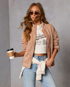 Tan quilted jacket with stand collar and zipper, long sleeves, and stitched panel seams