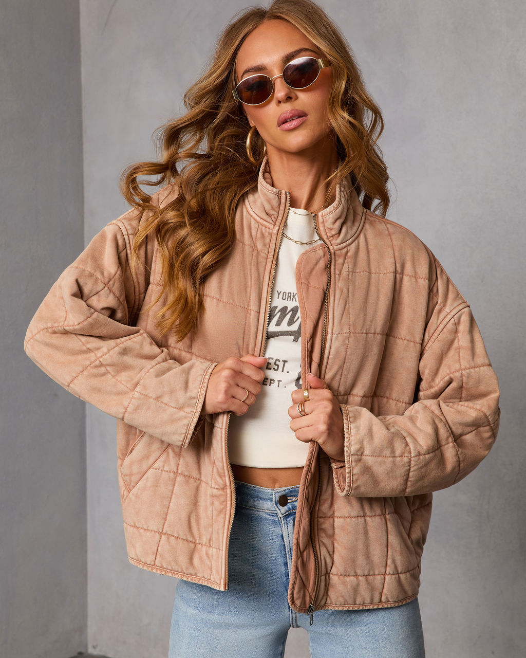 Beige quilted jacket with full-zip front, stand collar, and front patch pockets.