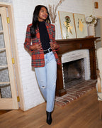 Women’s plaid blazer with padded shoulders, red multi check, long sleeves over black top.