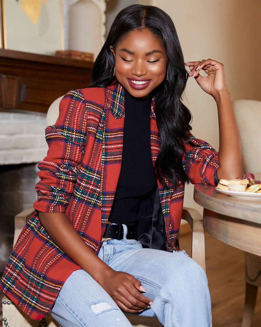 Red plaid blazer with padded shoulders, open front, long sleeves over a black top.