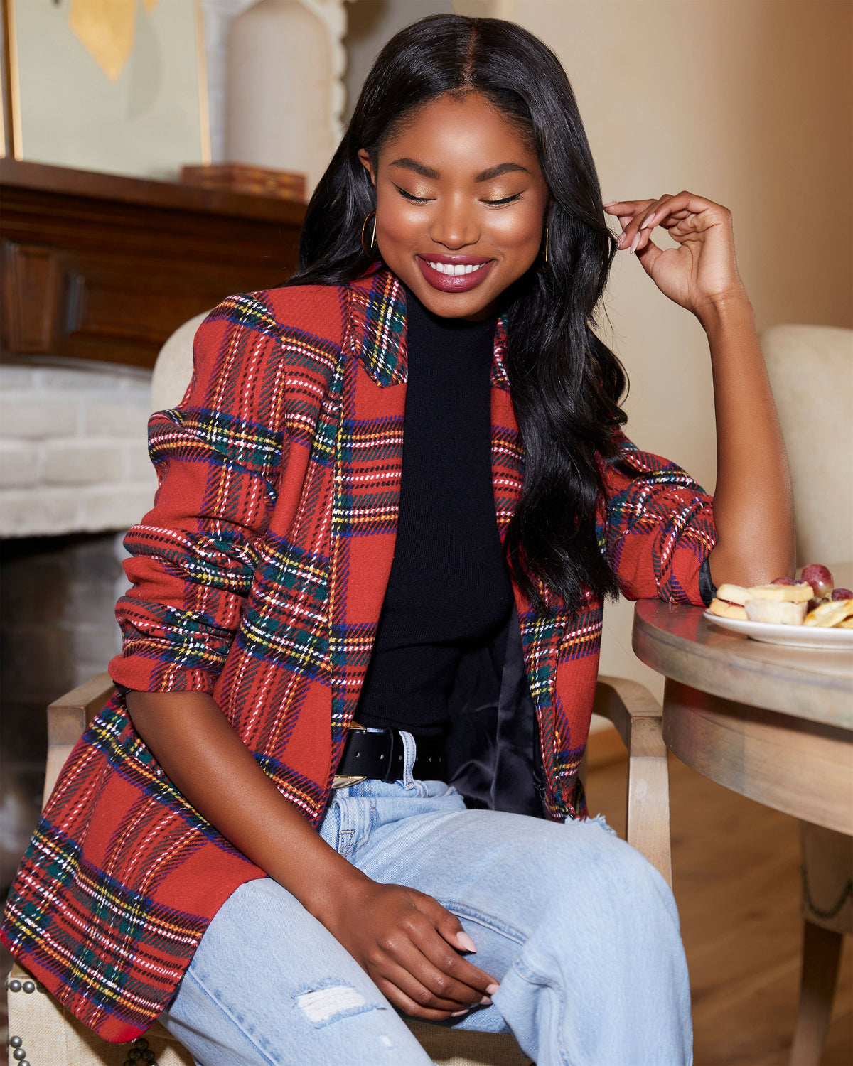 Red plaid blazer with padded shoulders, open front, long sleeves over a black top.