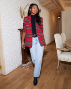 Women’s red plaid blazer with padded shoulders, long sleeves, worn over light blue jeans.