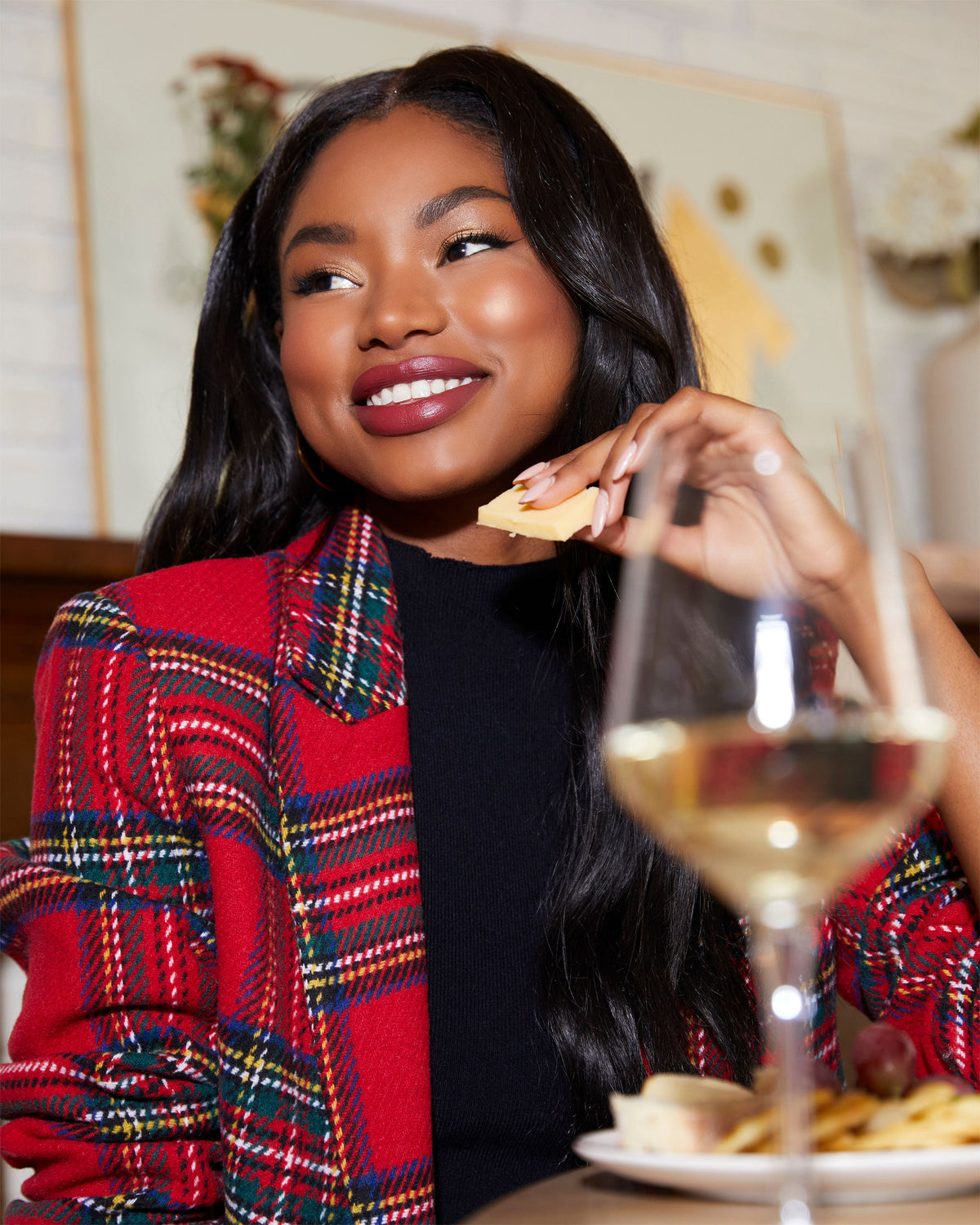 Red plaid blazer with padded shoulders over black top, open front, long sleeves.