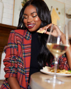 Red plaid blazer with padded shoulders over a black top, long sleeves, open front.