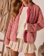 Close-up pink quilted zip jacket with stand collar, stitched panels, and ribbed cuffs