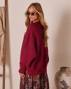 Oversized knit pullover sweater in deep red, side view with long sleeves and ribbing
