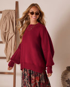 Oversized knit pullover sweater in deep red with wide dropped shoulders and ribbed hem