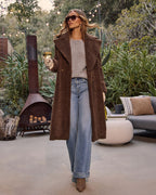 Brown teddy coat standing full length, open front with side pockets, plush texture
