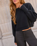 Black knit cropped crewneck sweater with ribbed cuffs and rounded neckline