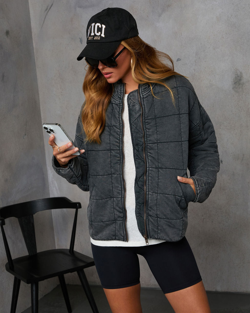 Charcoal quilted jacket with zip-front and quilted panels; back and side view.