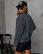 Charcoal quilted jacket with zip-front; back view with stand collar and hem cuffs.
