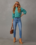 Mock neck sweater in teal, full-body view with long sleeves and ribbed hem over jeans