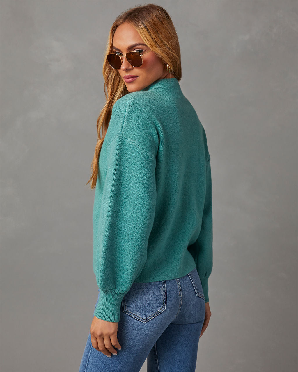 Mock neck sweater in teal, back/side view showing full sleeves and ribbed neckline