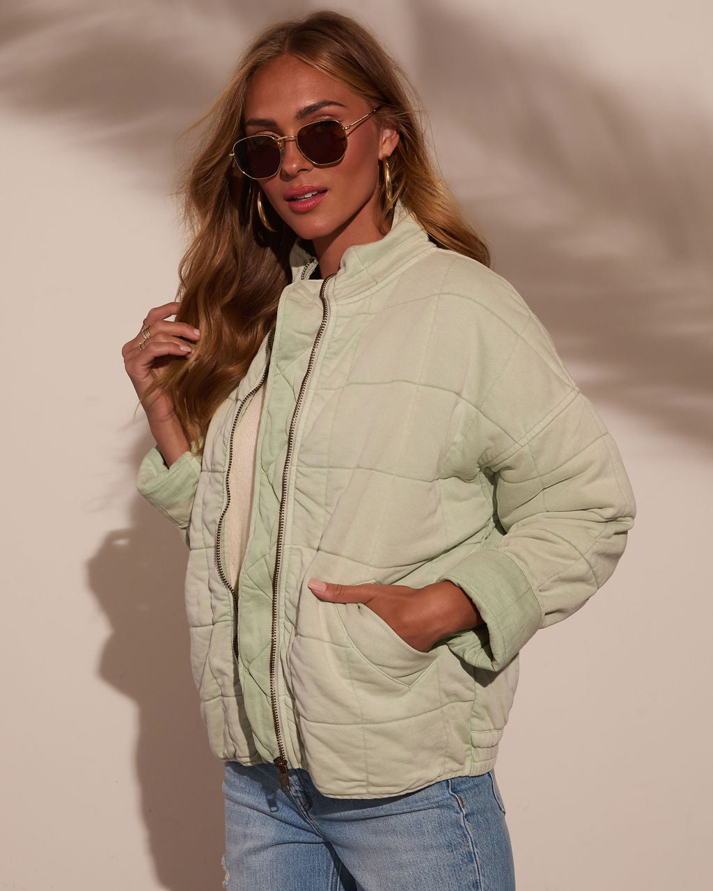 Light green quilted jacket with zip front, stand collar, and patch pockets.
