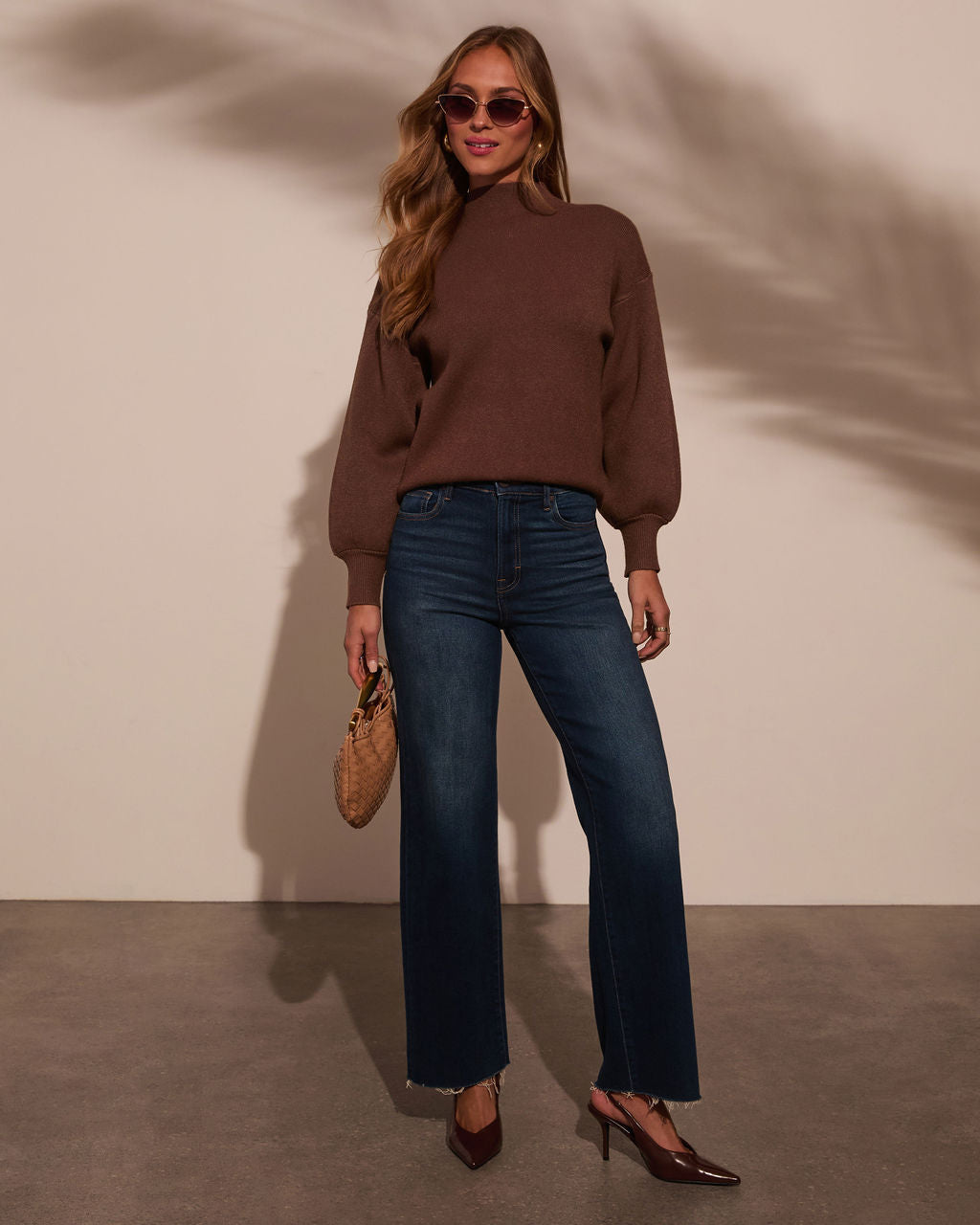 Mock neck sweater in dark brown, full-body view with long sleeves over blue jeans