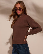 Mock neck sweater in dark brown with ribbed cuffs and hem, styled with blue jeans