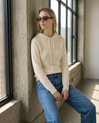 Women's knit hoodie in light beige with drawstring hood, front pocket, side view