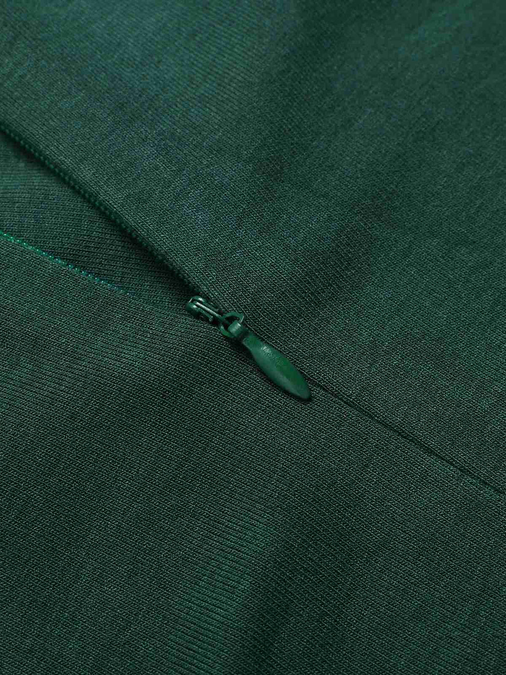Green placket with small zipper pull detail at neckline