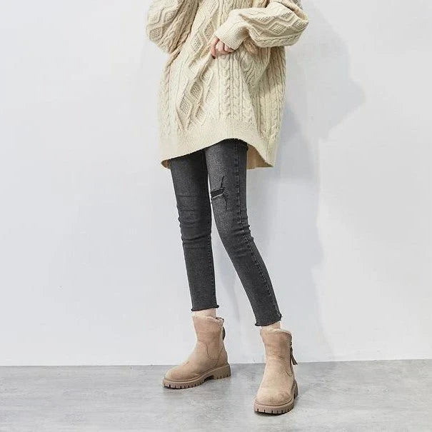 Beige suede winter boots with faux-fur lining and side zipper, worn with dark jeans
