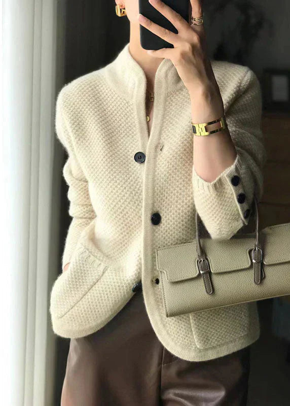 Cream white cardigan with button closure and dark buttons, long sleeves, cozy knit texture