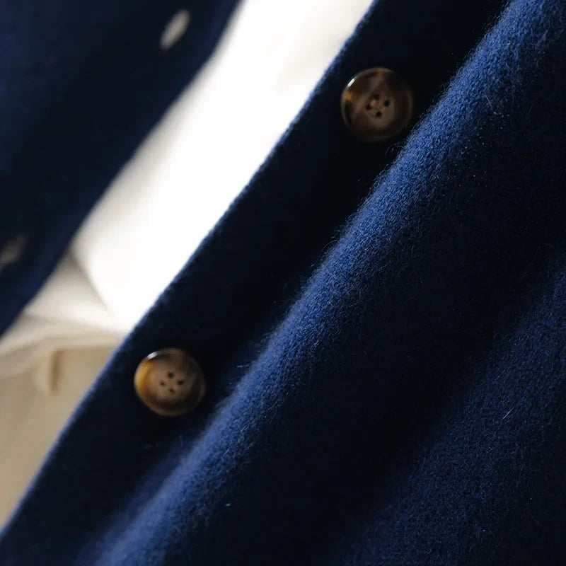 Navy cardigan close-up with round button detail on placket.