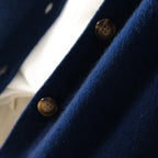 Navy cardigan close-up with round button detail on placket.