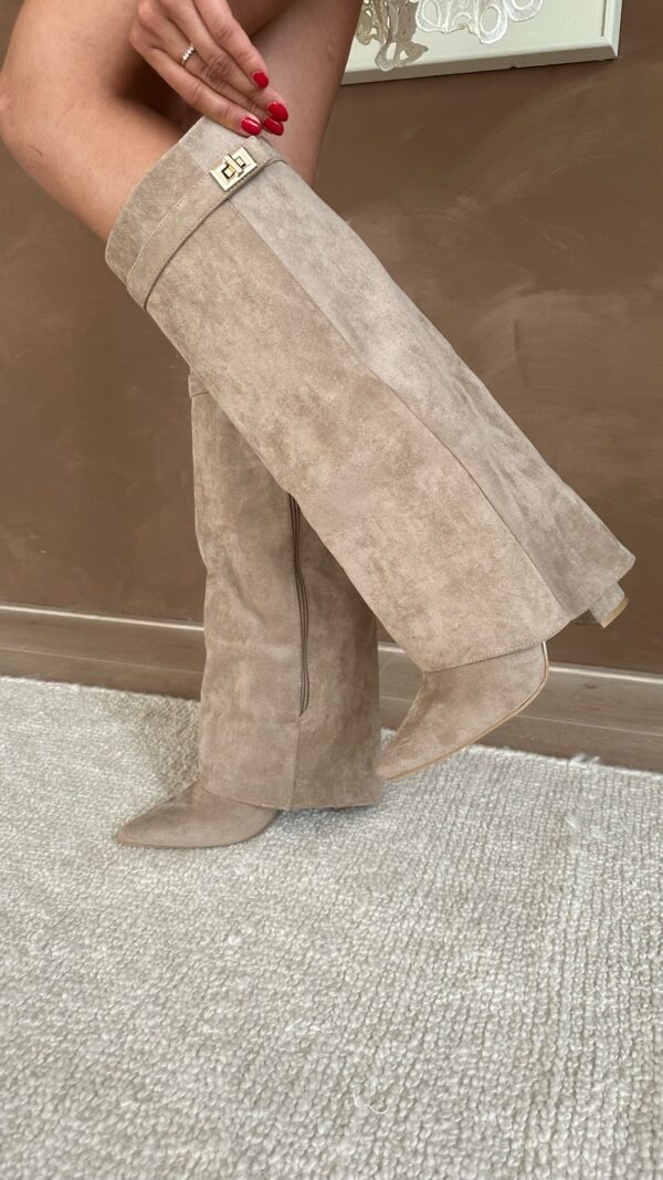 Beige suede tall heeled boots angled view with gold buckle detail on cuff.