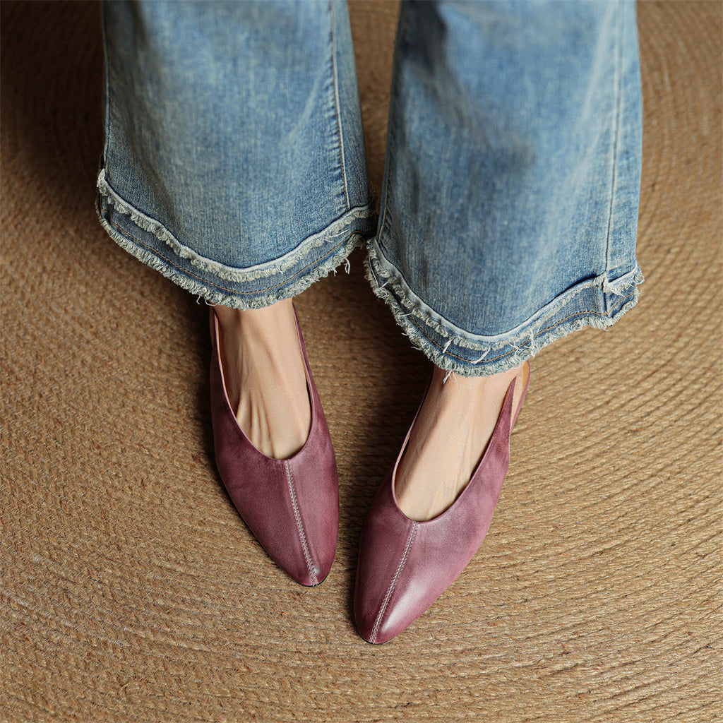Mauve genuine leather pointed-toe flats on feet with curved toe profile