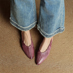 Mauve genuine leather pointed-toe flats on feet with curved toe profile