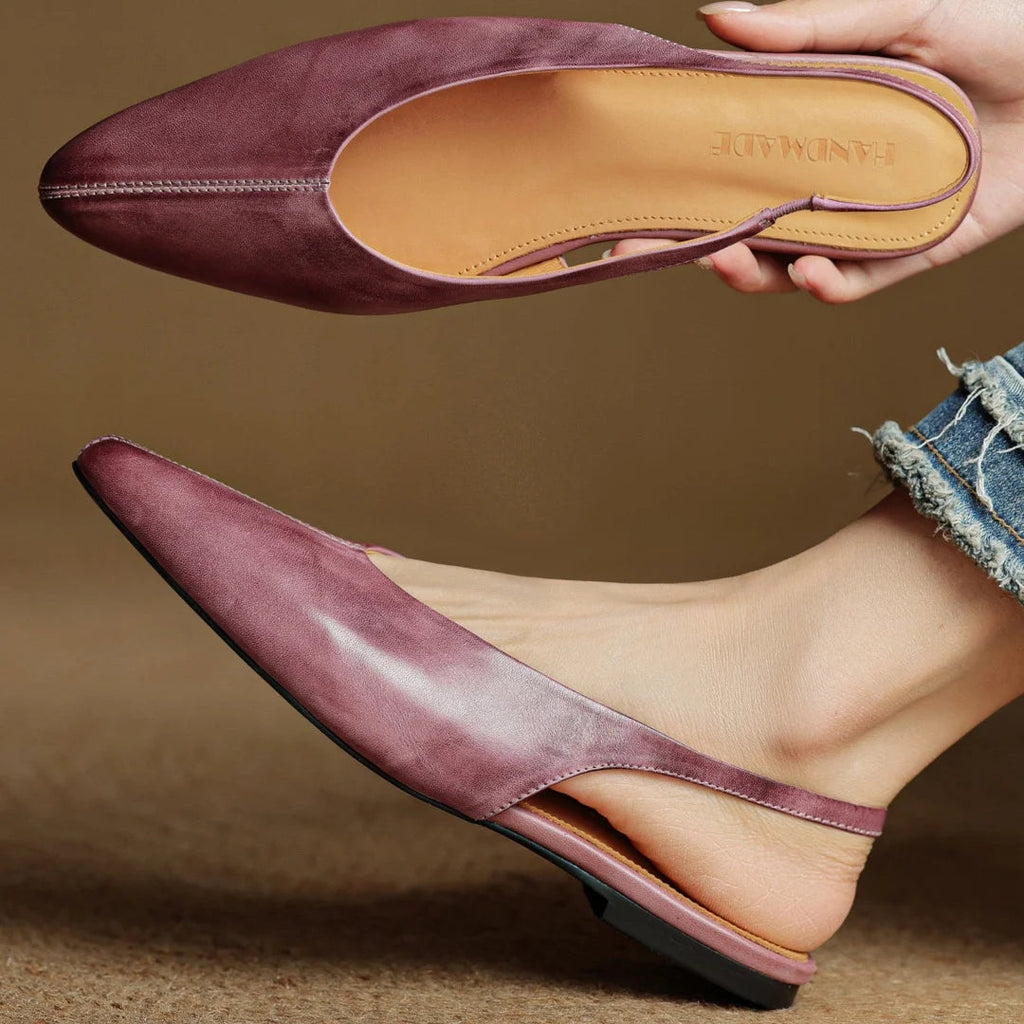 Mauve genuine leather pointed-toe flats, outsole and insole view in hand