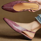 Mauve genuine leather pointed-toe flats, outsole and insole view in hand