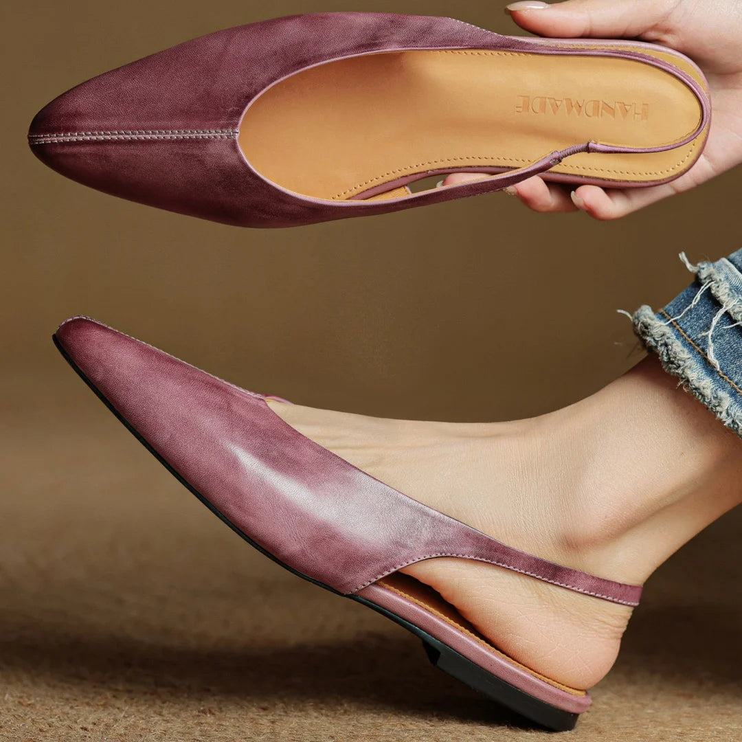 Mauve genuine leather pointed-toe flats, outsole and insole view in hand