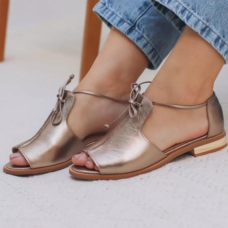 Champagne metallic leather sandals with toe strap, lace ankle tie, and low sole