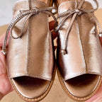 Champagne metallic leather peep-toe sandals, front draped panels and knotted ankle laces