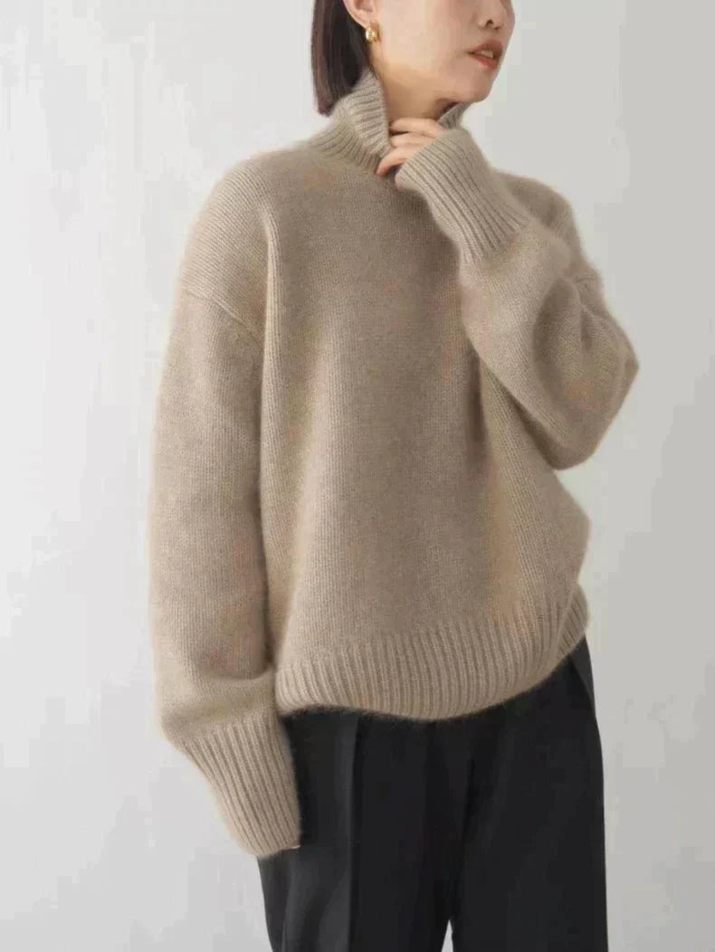 Beige turtleneck knit sweater with ribbed collar and relaxed long sleeves.
