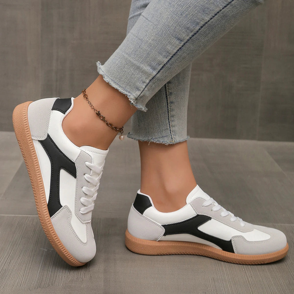 Black and white lace-up sneakers with contrasting stripe and gum rubber sole