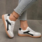 Black and white lace-up sneakers with contrasting stripe and gum rubber sole
