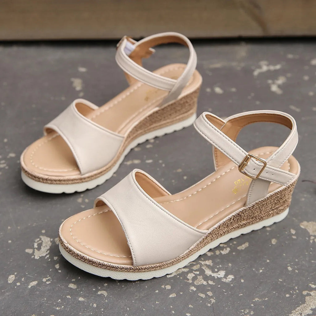 Beige heeled sandals pair with ankle buckle and woven jute-style wedge