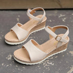 Beige heeled sandals pair with ankle buckle and woven jute-style wedge