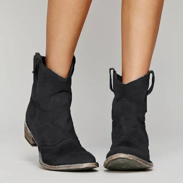 Black suede cowboy ankle boots with pointed toe, stacked block heel, side pull tabs.