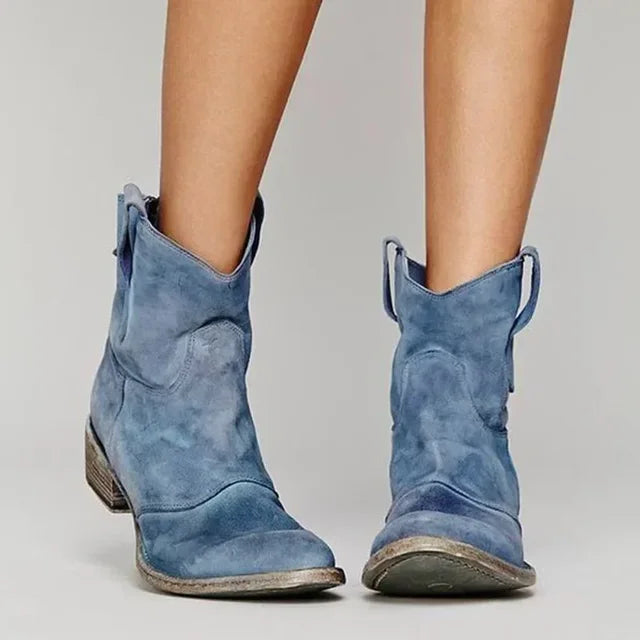 Blue suede cowboy ankle boots with pointed toe, stacked block heel, side pull tabs.