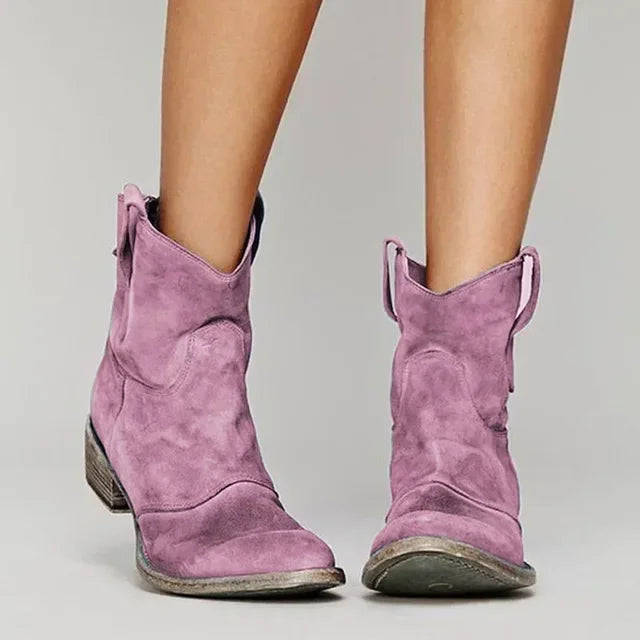 Pink suede cowboy ankle boots with pointed toe, stacked block heel, side pull tabs.