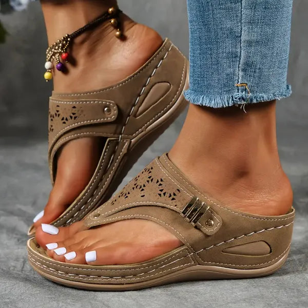 Women's tan cutout wedge sandals with perforated design, adjustable buckle strap