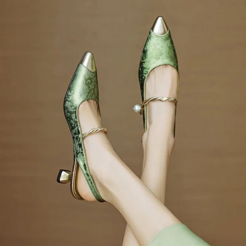 Green elegant pumps with pointed toe, ankle strap, and pearl detail, side view
