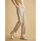 Khaki tapered trousers with high waist, belt loops, and front pleats