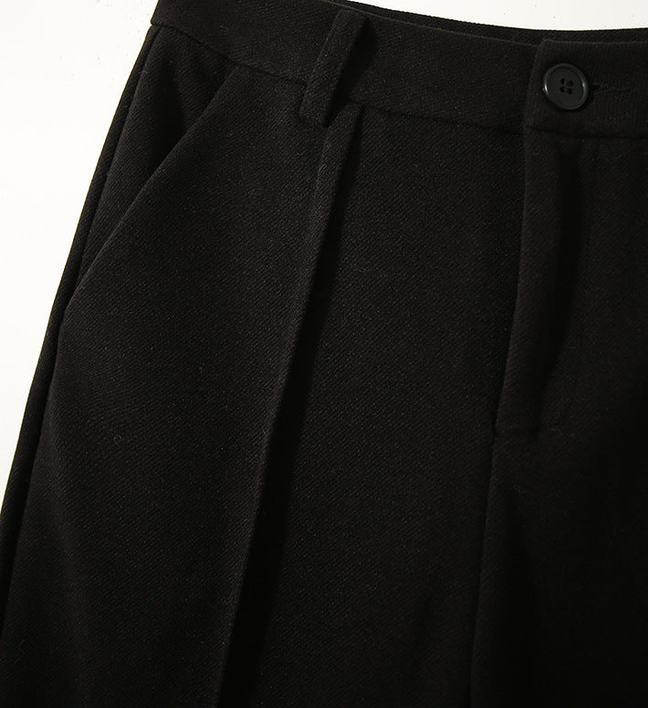 Black high-waisted wool-blend trousers with pleated front, belt loops, and button